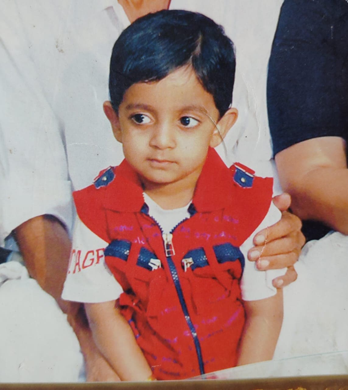 Childhood photo of Sreedev Krishna in a red vest.